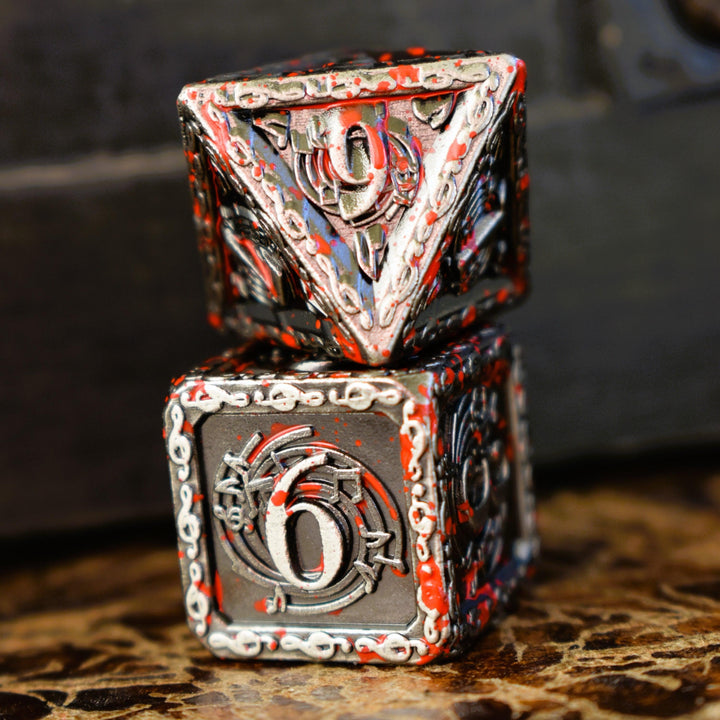 A set of silver metal dice with musical note details around the silver numbers splattered in red blood on a wooden surface, including various shapes such as a d4, d6, d8, d10, d12, and d20.