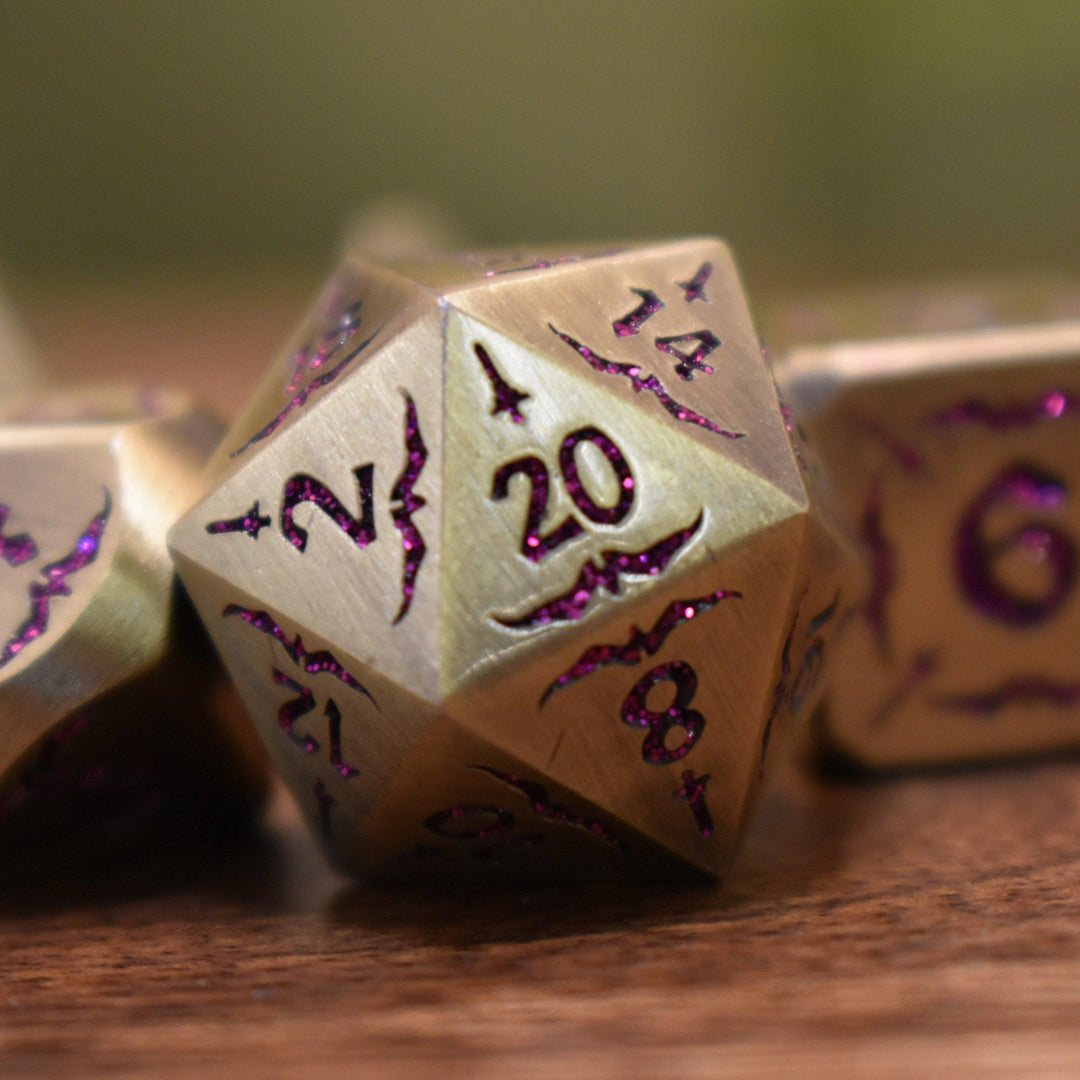 bronze metal dnd dice set with pink glitter numbering and sword details for tabletop gaming and board games
