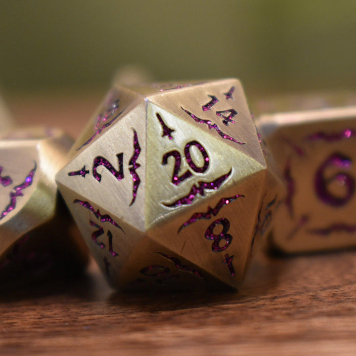 bronze metal dnd dice set with pink glitter numbering and sword details for tabletop gaming and board games