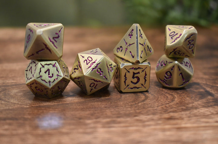bronze metal dnd dice set with pink glitter numbering and sword details for tabletop gaming and board games