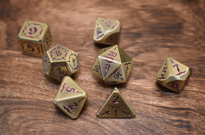 bronze metal dnd dice set with pink glitter numbering and sword details for tabletop gaming and board games