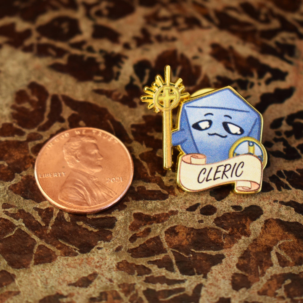 A Cleric class dice pin with a blue enamel finish, gold detailing, and the word 'CLERIC' displayed on a banner.