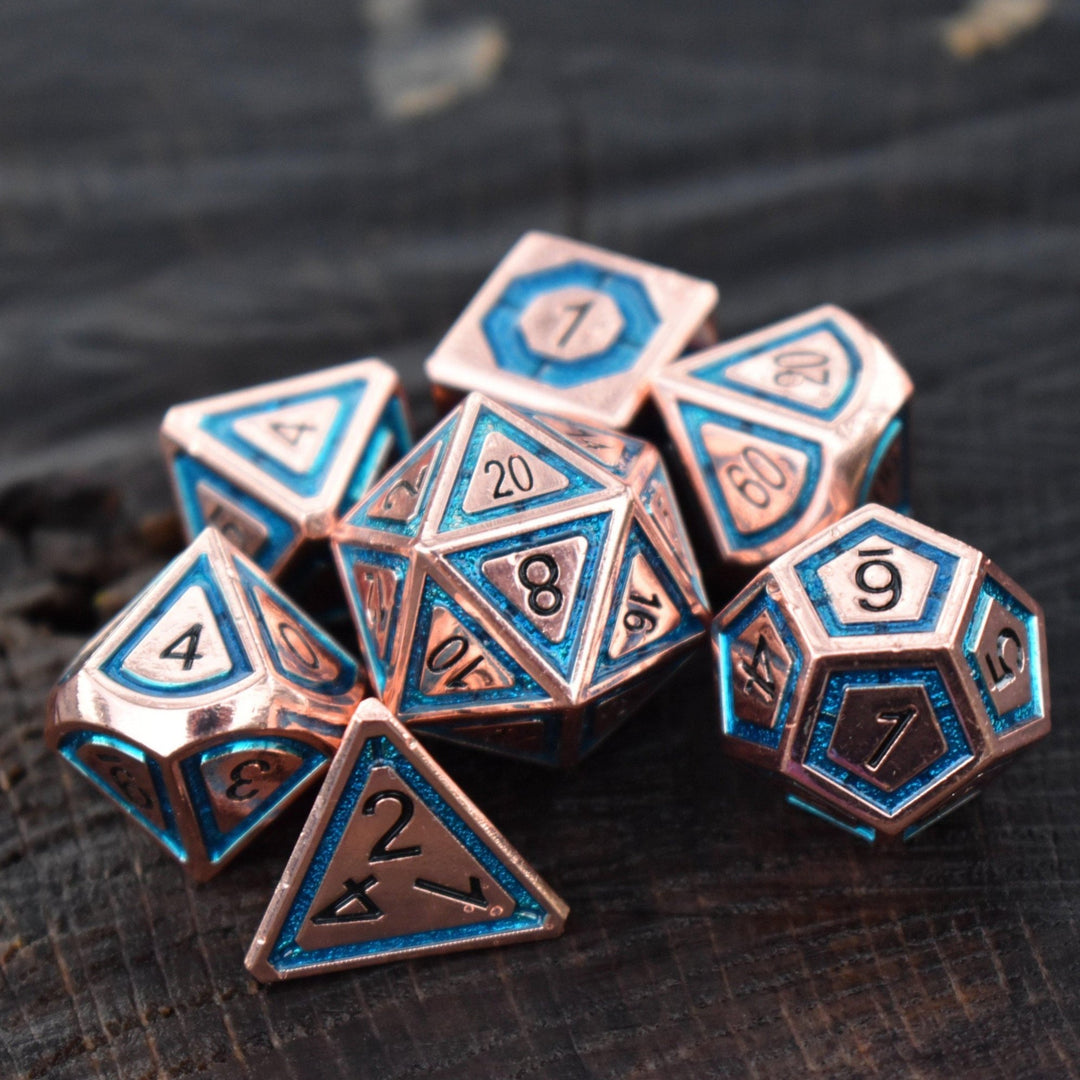 A set of bronze metal dice with aqua blue borders on each face and black numbering for tabletop gaming wargaming and board games