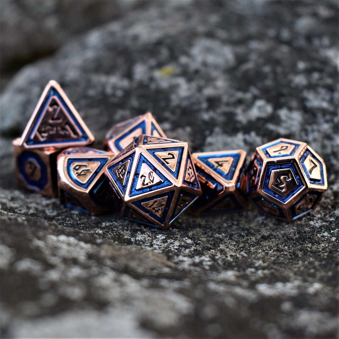 A set of bronze metal dice with aqua blue borders on each face and black numbering for tabletop gaming wargaming and board games
