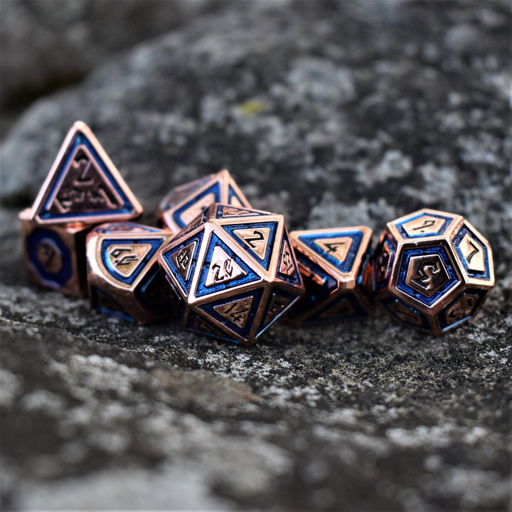 A set of bronze metal dice with aqua blue borders on each face and black numbering for tabletop gaming wargaming and board games