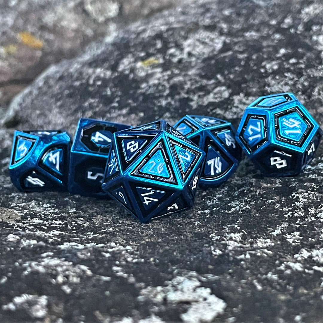 A set of blue metal dice with black borders on each face and white numbers