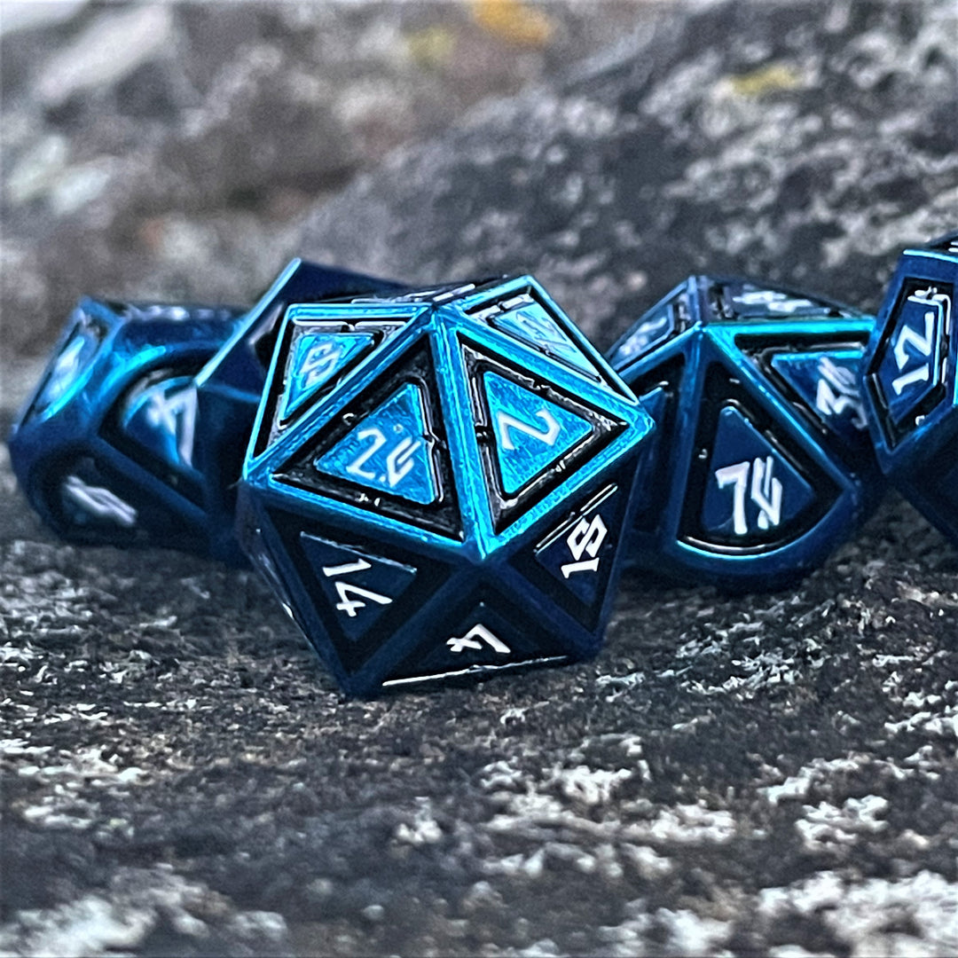 A set of blue metal dice with black borders on each face and white numbers