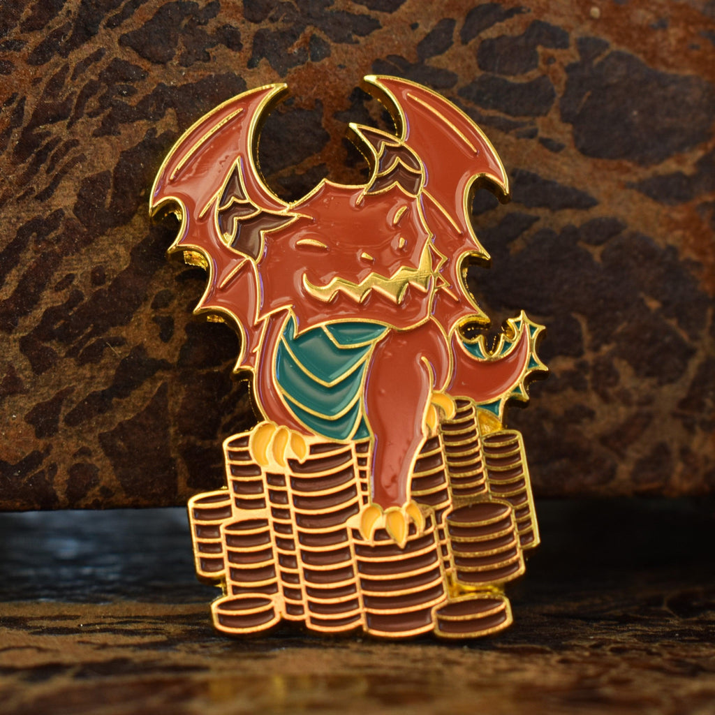 A metal enamel pin shaped like a red dragon sitting on top of a stack of gold coins.