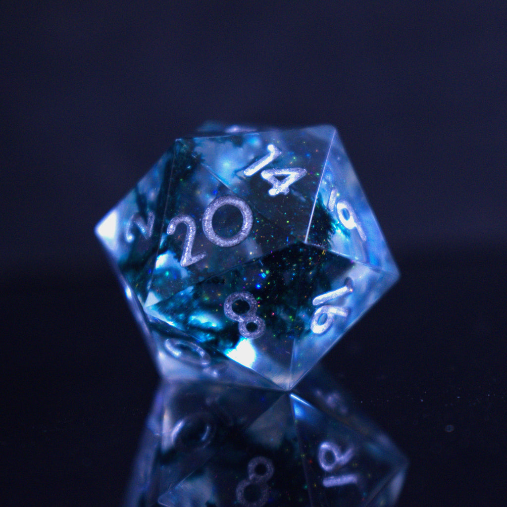 A set of sharp-edged resin dnd dice in blue with silver numbers and black and glitter details inside for ttrpg and board games