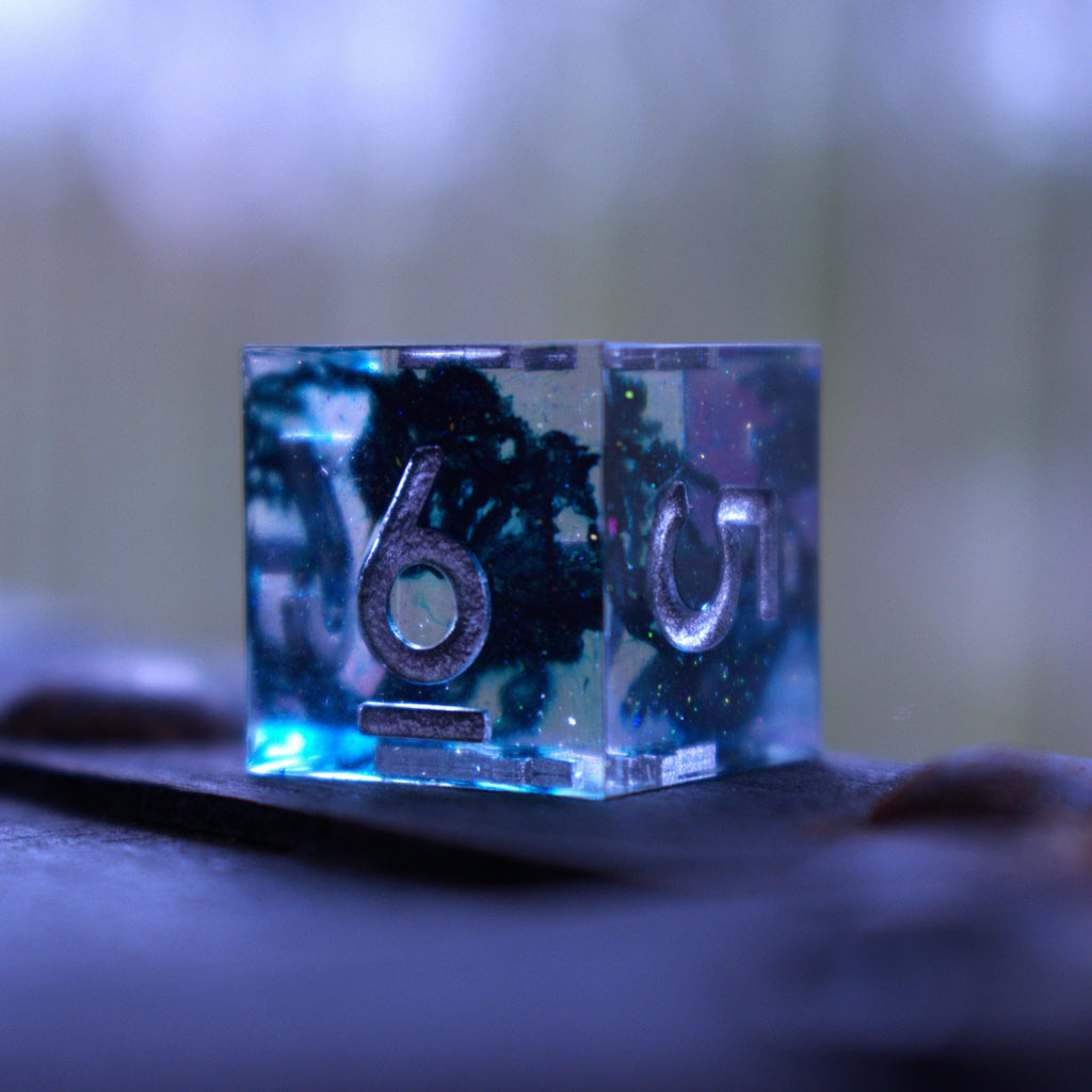 A set of sharp-edged resin dnd dice in blue with silver numbers and black and glitter details inside for ttrpg and board games