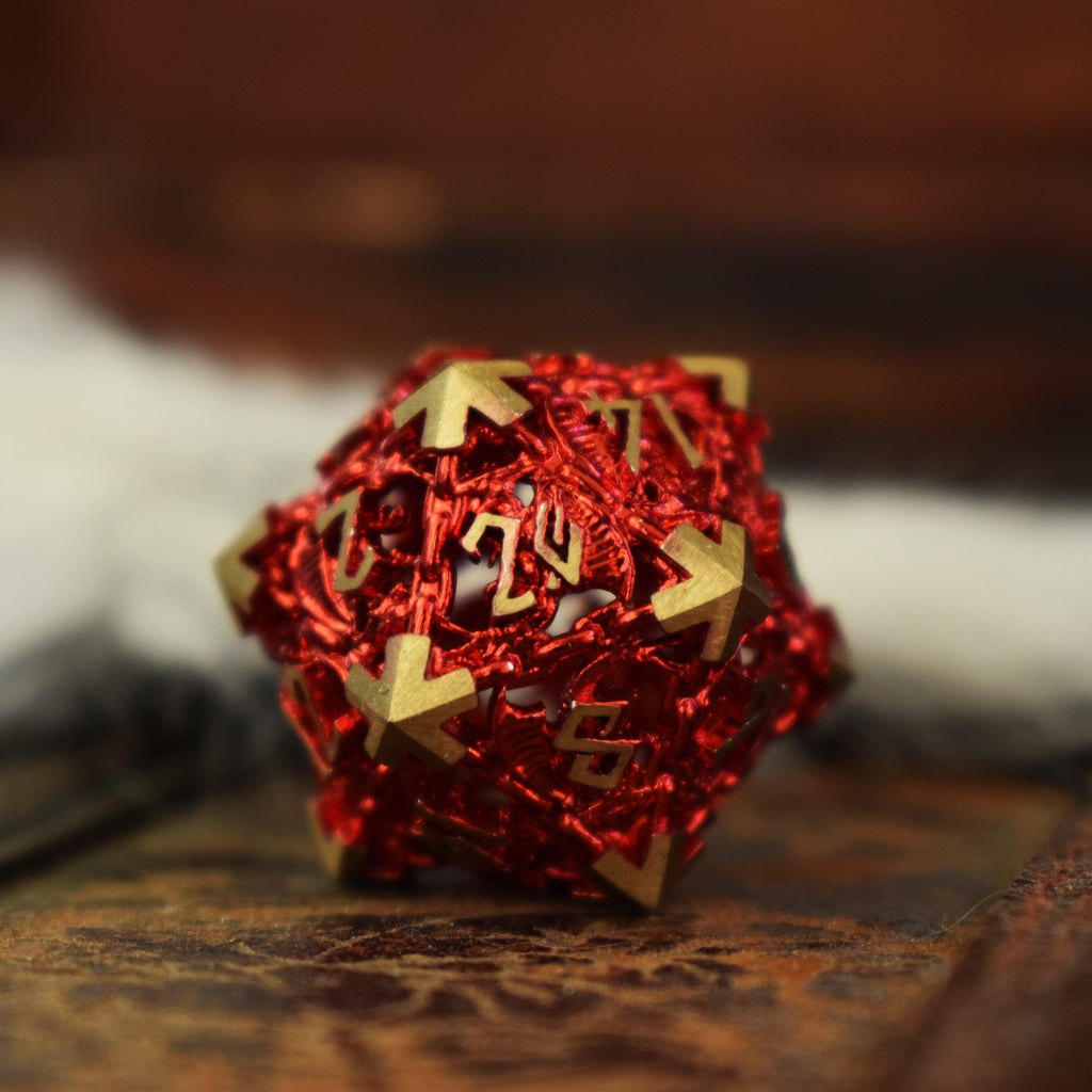 A set of red hollow metal dice with embossed numbers, displayed on a textured surface.