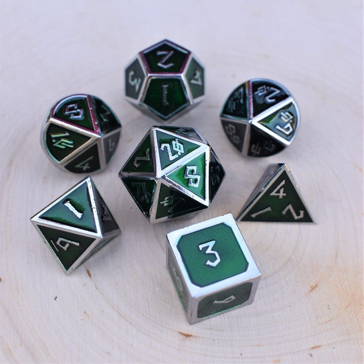A set of deep green metal polyhedral dnd dice with silver borders and numbering