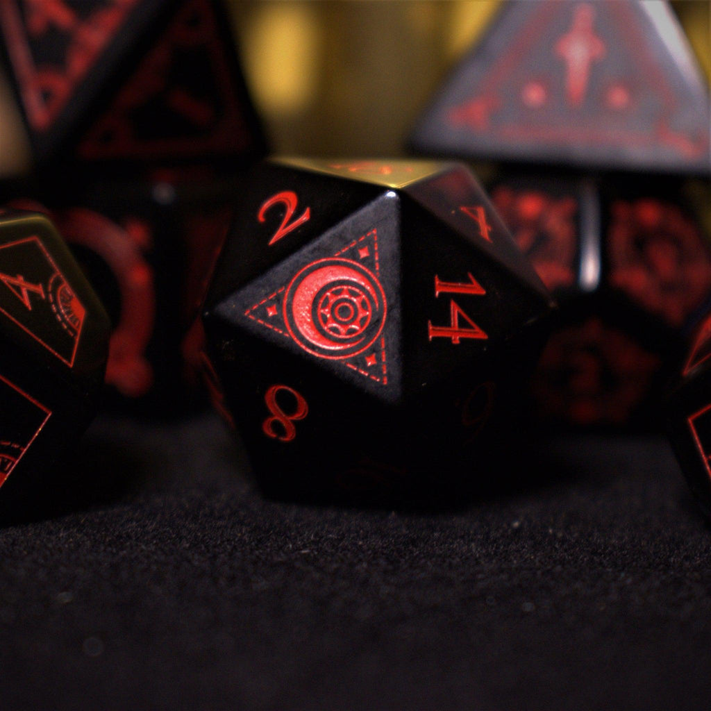 A set of black Obsidian gemstone dice with red engraved numbers and symbols, including a D4, D6, D8, two D10s, D12, and D20, displayed on a dark surface with a blurred light background.