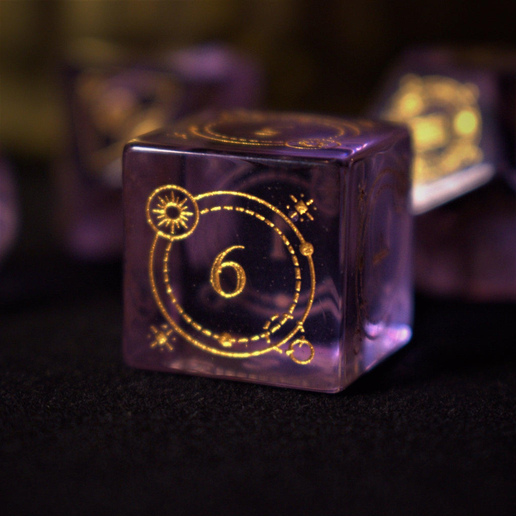 A set of purple glass dice with engraved golden numbers and detail, displayed on a dark surface with a light source in the background creating a reflective sheen on the dice.