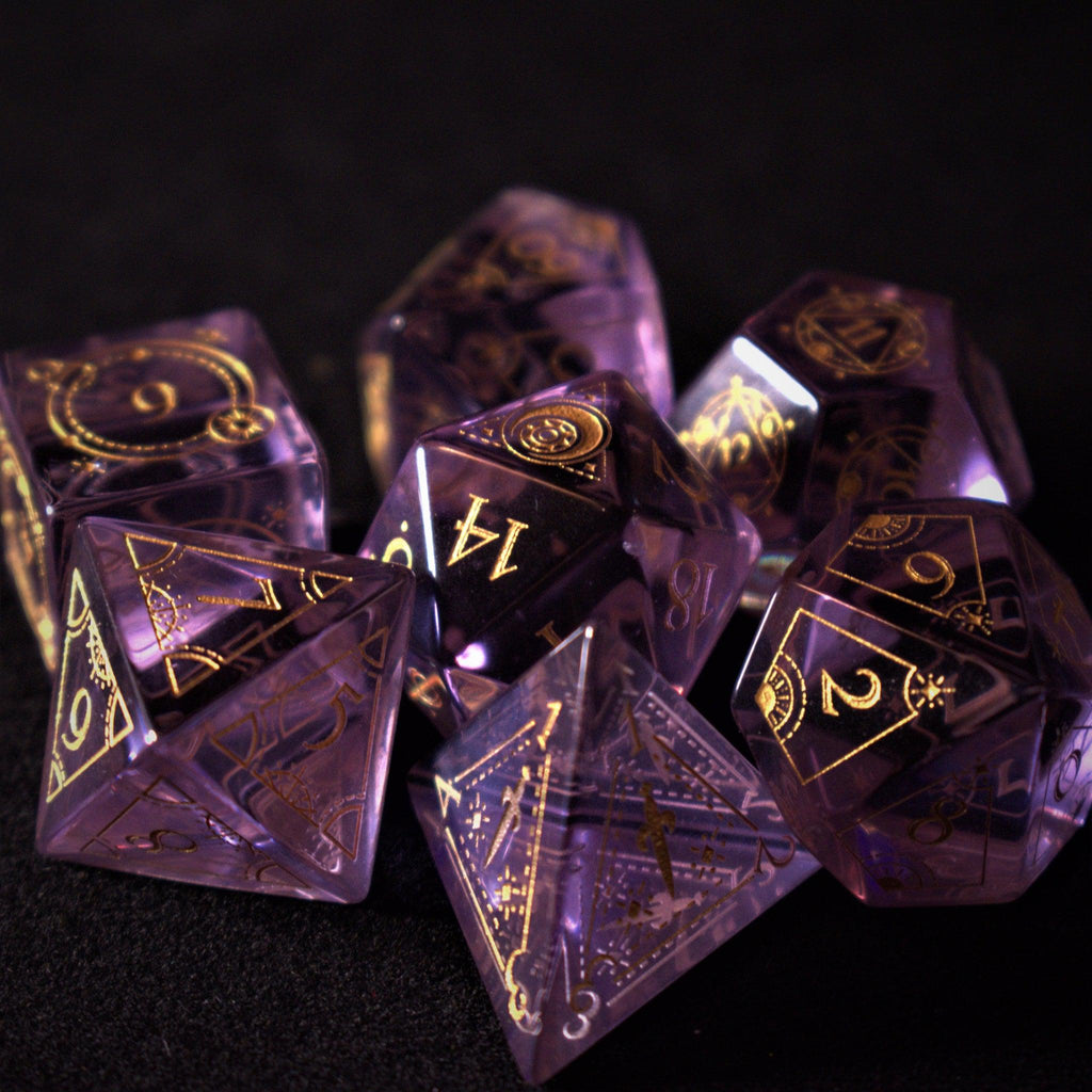 A set of purple glass dice with engraved golden numbers and detail, displayed on a dark surface with a light source in the background creating a reflective sheen on the dice.