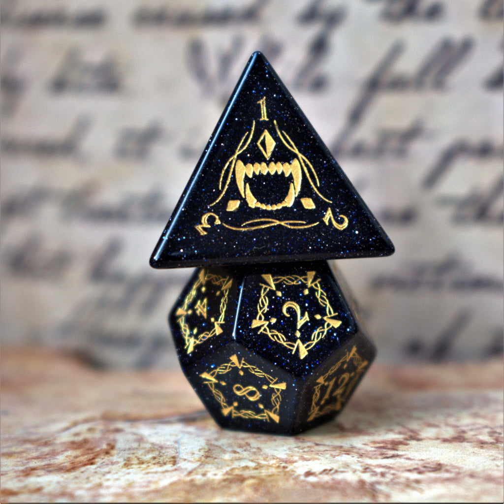 A set of Fangs of Winter Blue Sandstone Stone Dice with gold engravings on a textured background.