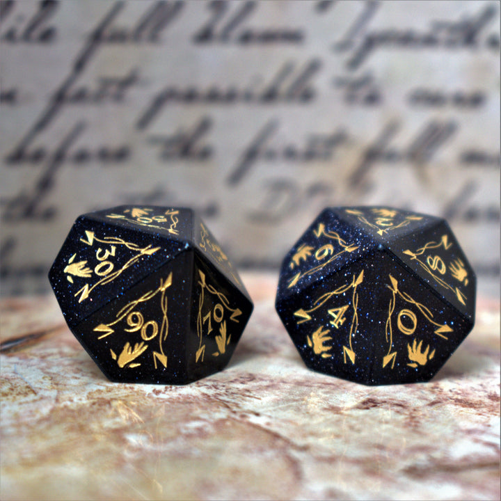 A set of Fangs of Winter Blue Sandstone Stone Dice with gold engravings on a textured background.
