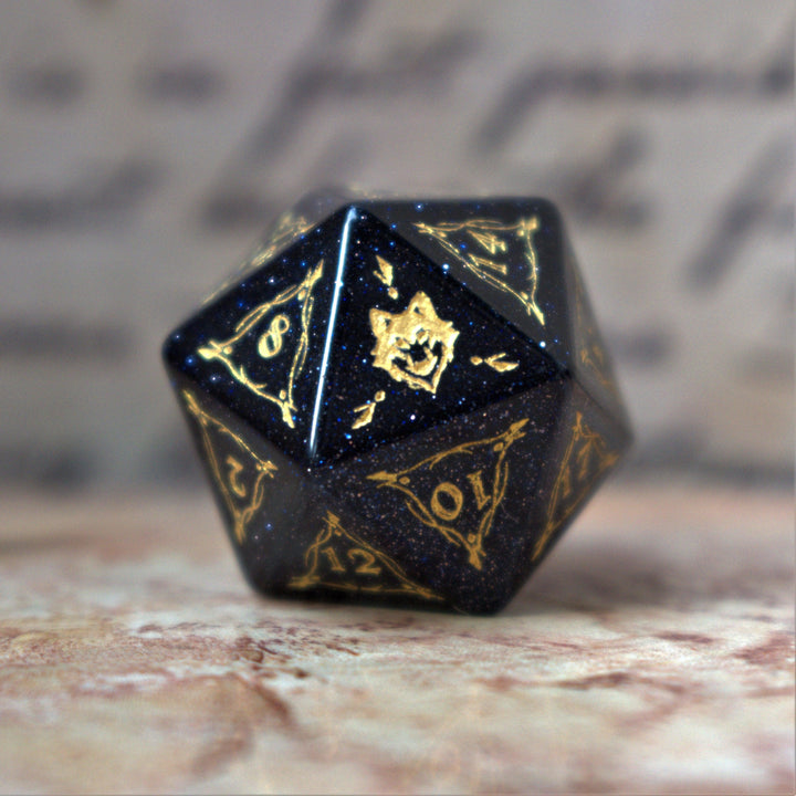 A set of Fangs of Winter Blue Sandstone Stone Dice with gold engravings on a textured background.