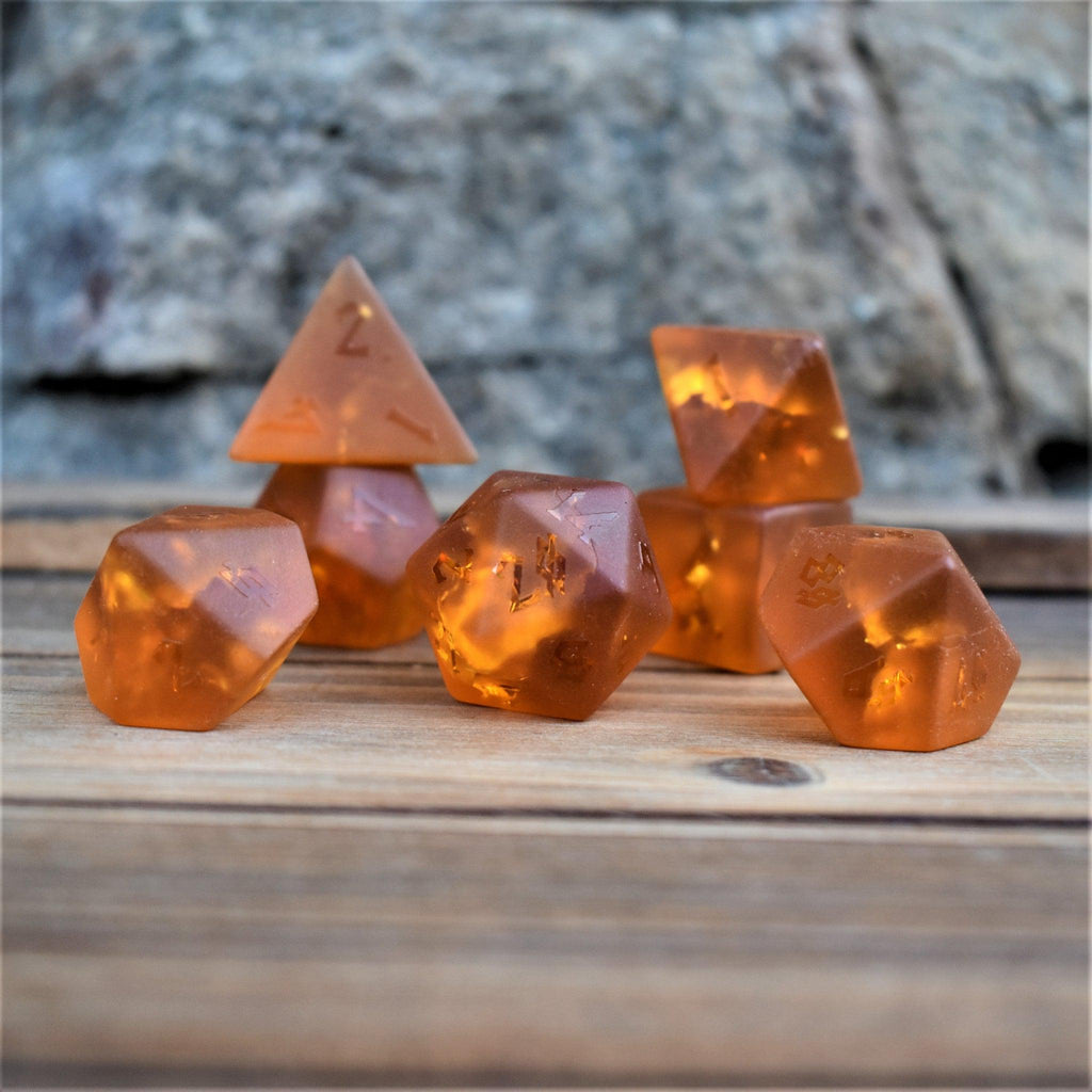 a set of 7 polyhedral dnd dice called Gates of Helheim Raised Lava Glass Dice on orange shattered matte glass with clear numbering 