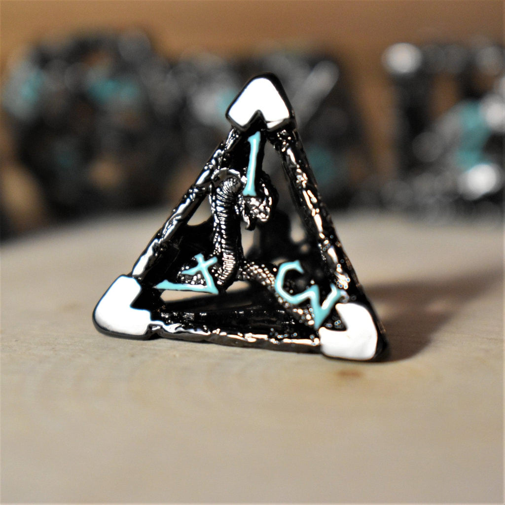 A set of hollow metal dice in black with blue embossed numbers, including various shapes such as a d4, d6, d8, d10, d12, and d20, displayed on a wooden surface.