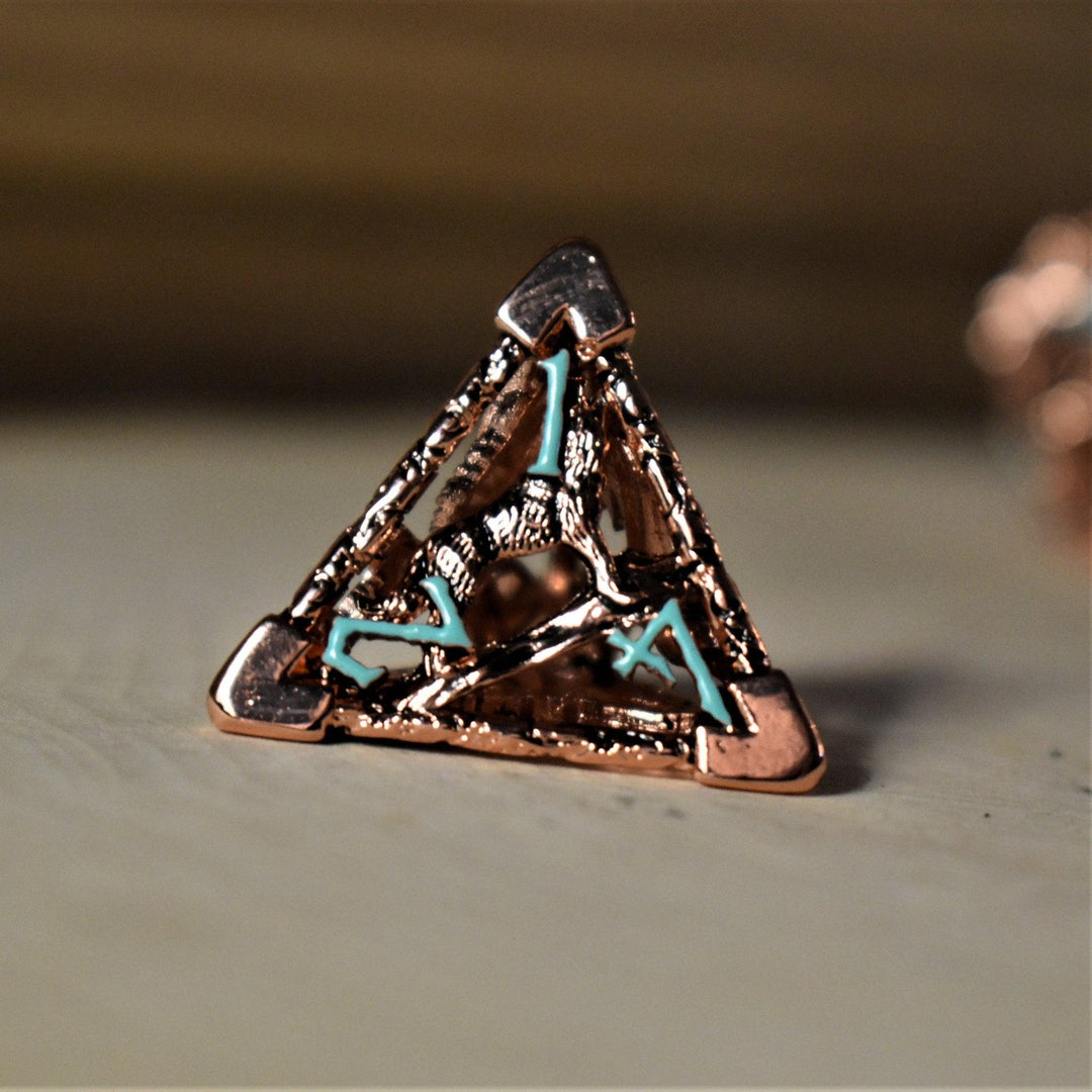 A set of copper-plated metal hollow dice with embossed numbers, including various shapes such as a D4, D6, D8, D10, D12, and D20, displayed on a wooden surface.