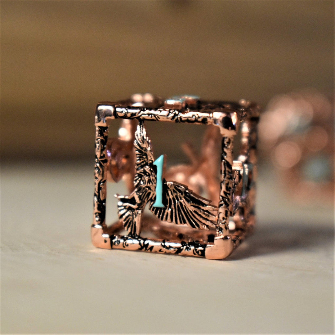 A set of copper-plated metal hollow dice with embossed numbers, including various shapes such as a D4, D6, D8, D10, D12, and D20, displayed on a wooden surface.