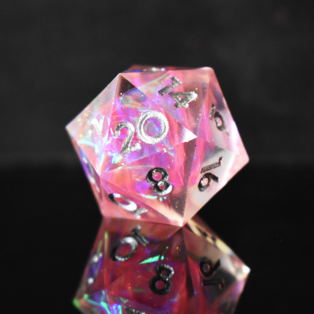 A set of sharp-edged, pink resin dnd dice with silver engraved numbers, reflecting a metallic sheen inside of each die