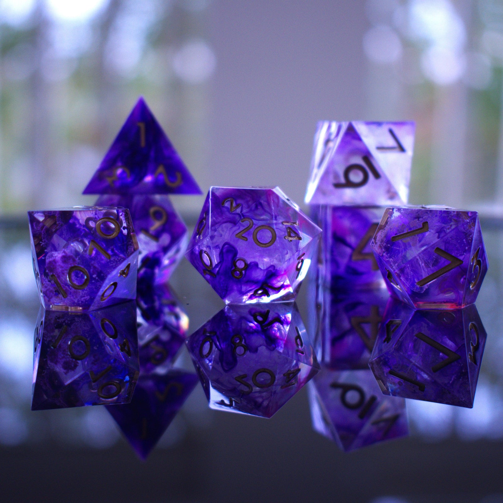 A set of sharp-edged, purple resin dice with engraved numbers, including various shapes such as a d4, d6, d8, d10, d12, and d20.
