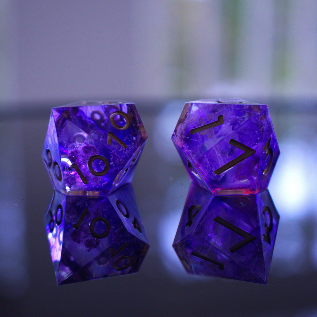 A set of sharp-edged, purple resin dice with engraved numbers, including various shapes such as a d4, d6, d8, d10, d12, and d20.