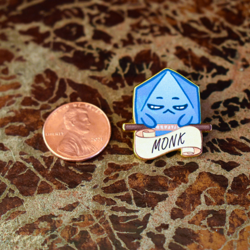 A pin with a blue dice character illustration labeled 'MONK' on a banner.