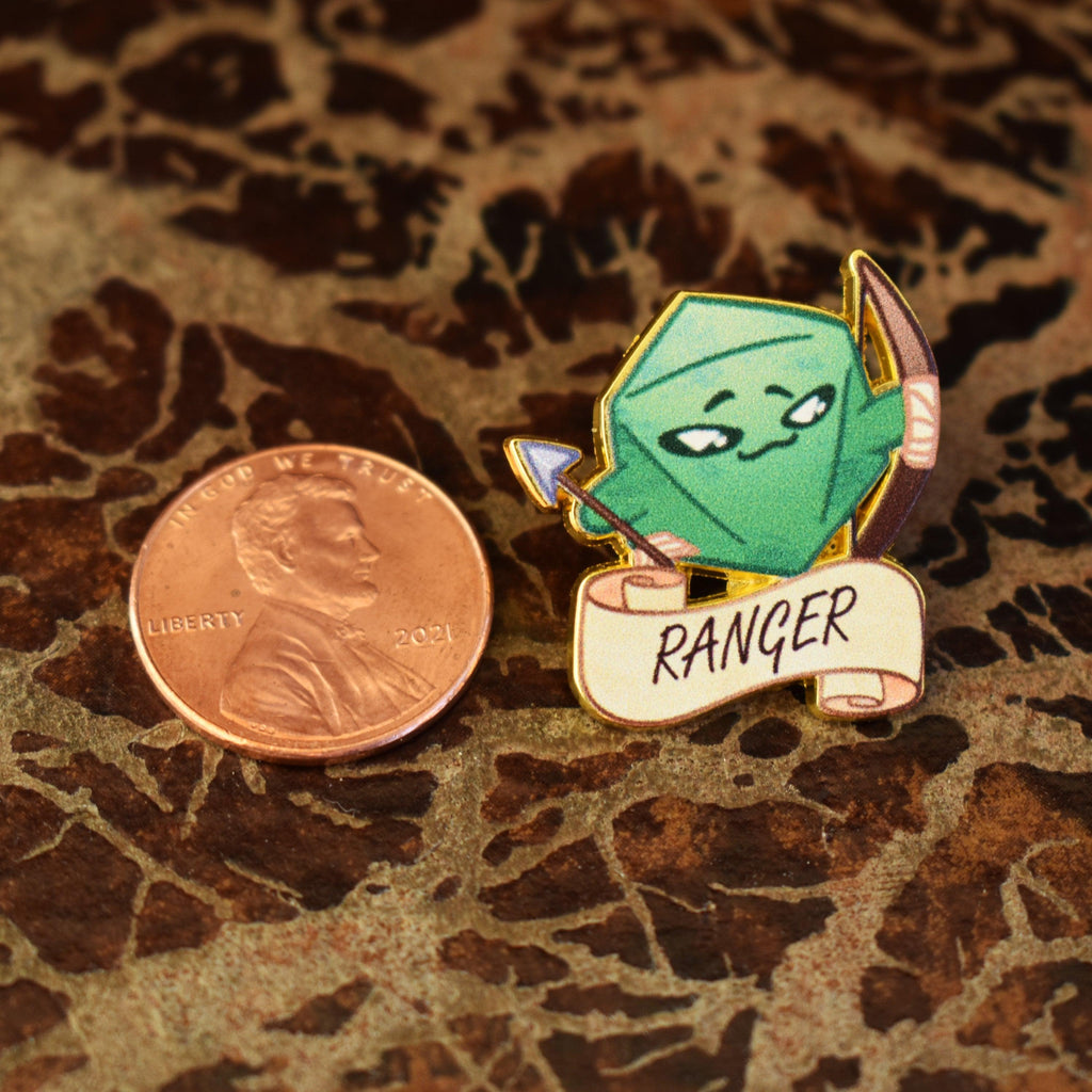 An enamel pin with a green, gold, and white color scheme featuring a ranger class character from a role-playing game, with the word 'RANGER' on a banner.