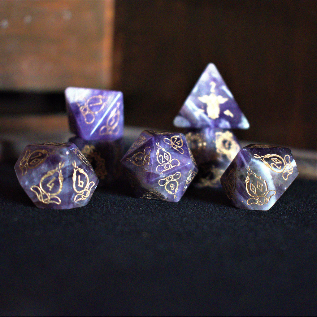 A set of viking inspired purple amethyst stone ttrpg dice with engraved numbers in gold