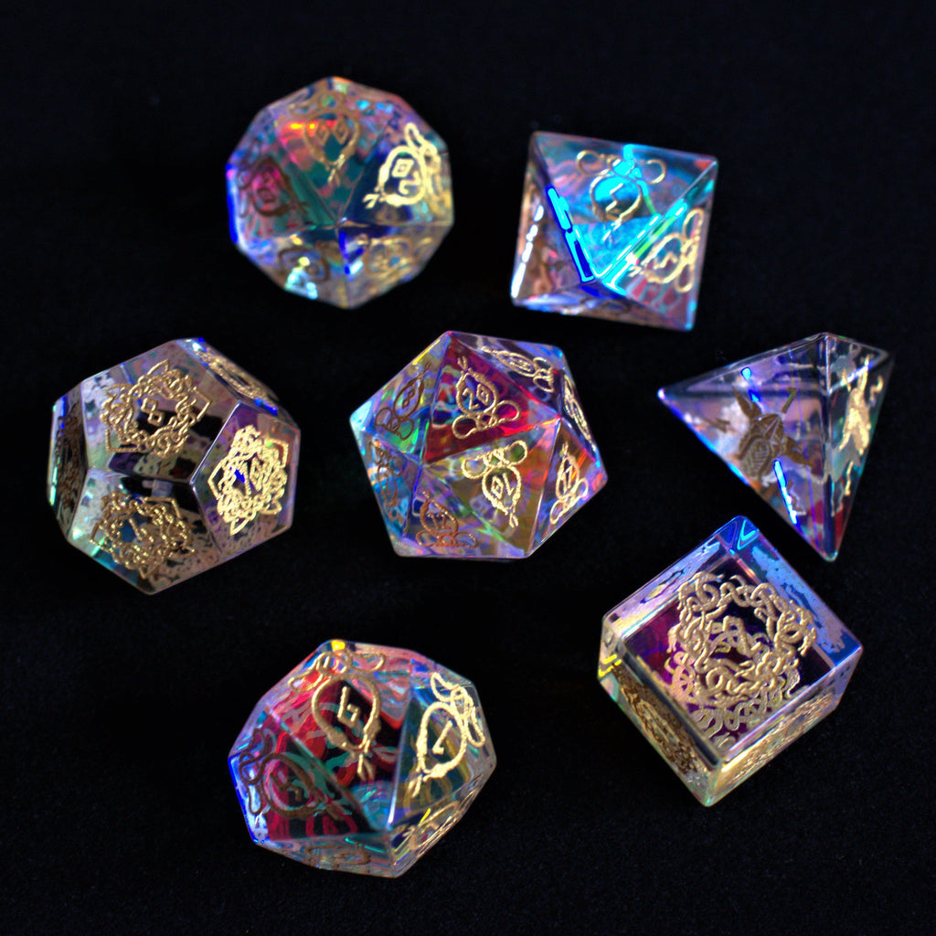A set of hand-carved, iridescent prism glass dnd dice with engraved numbers, including a D4, D6, D8, two D10s, D12, and D20.