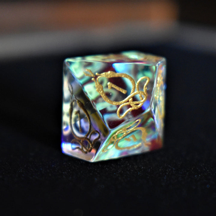 A set of hand-carved, iridescent prism glass dnd dice with engraved numbers, including a D4, D6, D8, two D10s, D12, and D20.