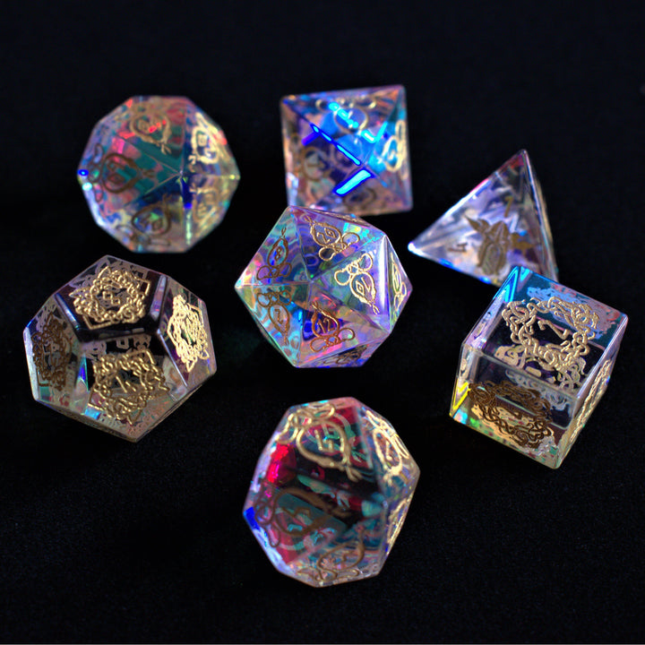 A set of hand-carved, iridescent prism glass dnd dice with engraved numbers, including a D4, D6, D8, two D10s, D12, and D20.