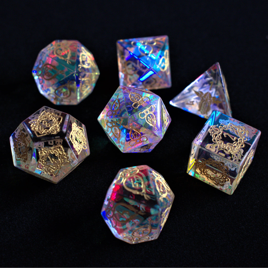 A set of hand-carved, iridescent prism glass dnd dice with engraved numbers, including a D4, D6, D8, two D10s, D12, and D20.