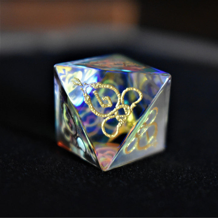 A set of hand-carved, iridescent prism glass dnd dice with engraved numbers, including a D4, D6, D8, two D10s, D12, and D20.