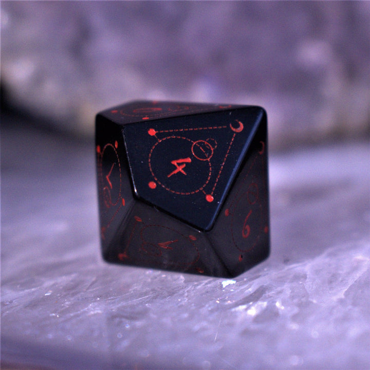 A set of Spellcaster Obsidian Stone polyhedral Dice with red engraved numbers and symbols