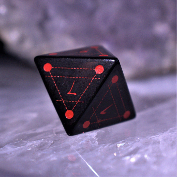 A set of Spellcaster Obsidian Stone polyhedral Dice with red engraved numbers and symbols