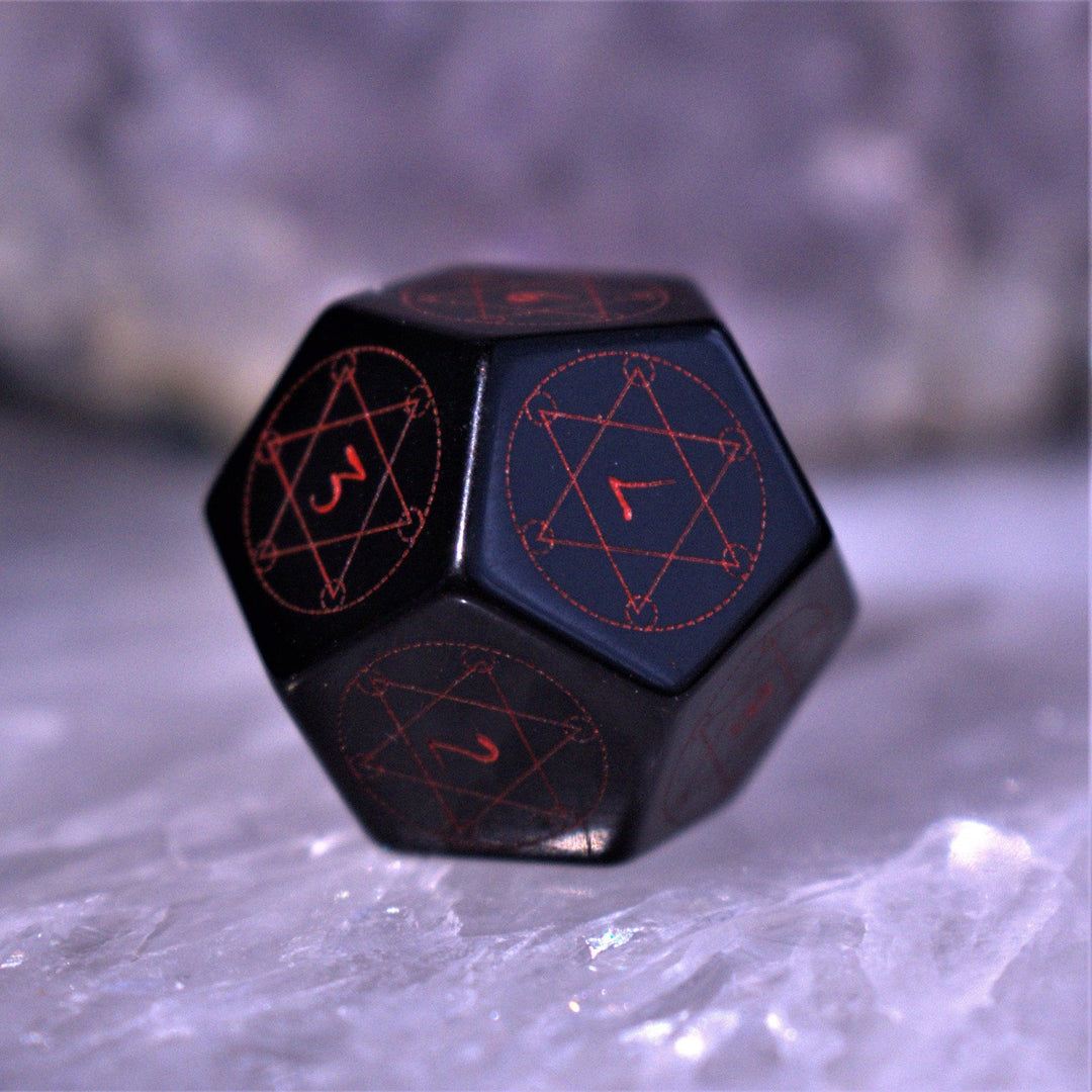 A set of Spellcaster Obsidian Stone polyhedral Dice with red engraved numbers and symbols
