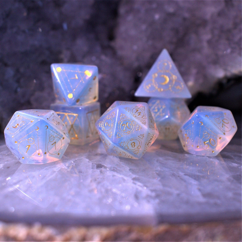 A set of hand-carved, Opalite gemstone dnd dice with engraved and golden hand-painted designs to create an iridescent spellcasting experience  