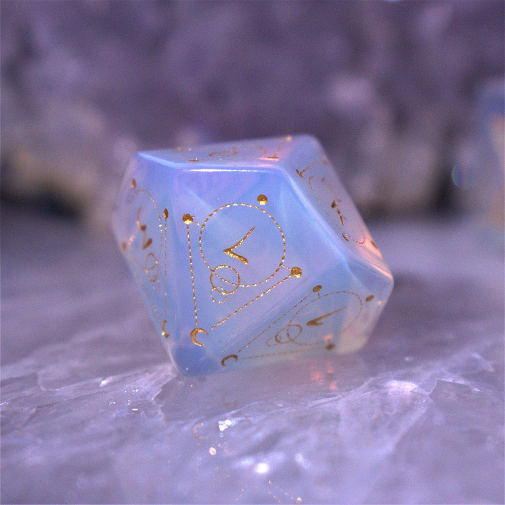 A set of hand-carved, Opalite gemstone dnd dice with engraved and golden hand-painted designs to create an iridescent spellcasting experience  