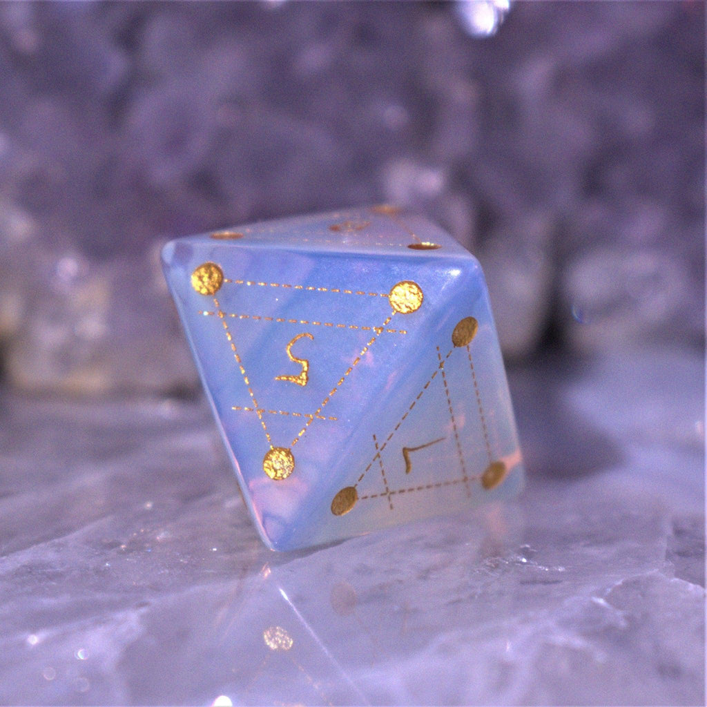 A set of hand-carved, Opalite gemstone dnd dice with engraved and golden hand-painted designs to create an iridescent spellcasting experience  