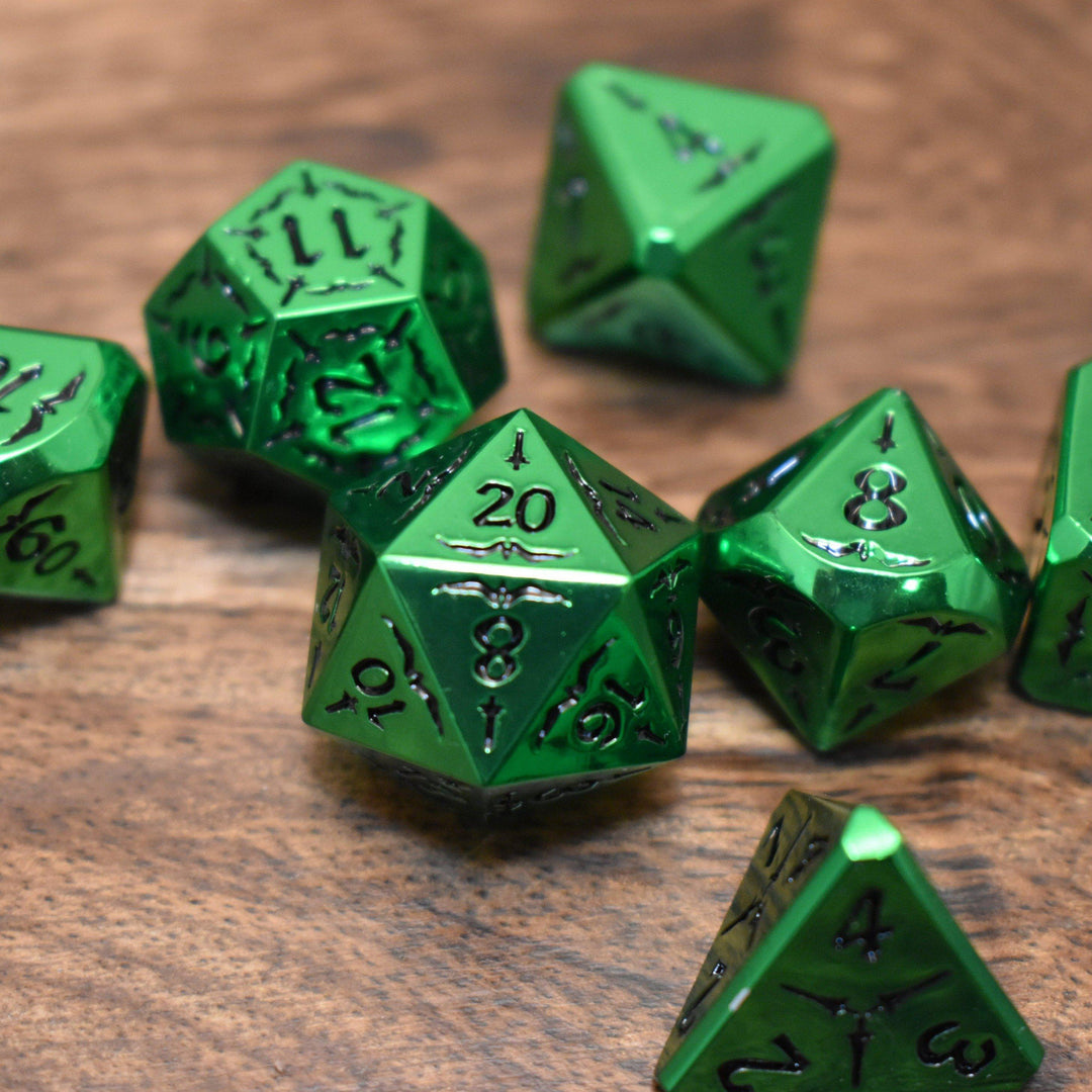 A set of solid metal green metallic dnd polyhedral dice with black numbering and sword details for tabletop gaming and board games