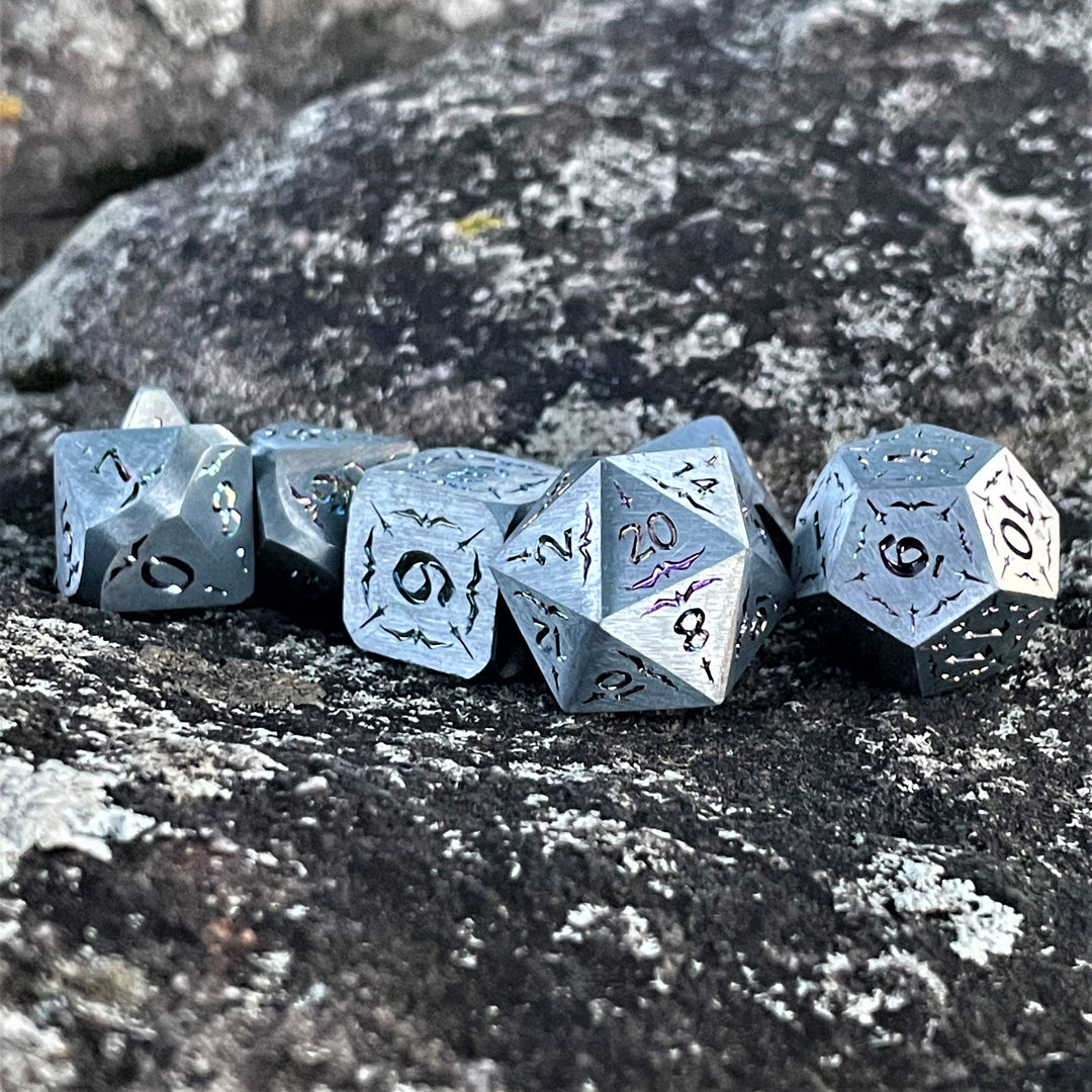 A set of solid silver metal dnd dice with iridescent numbering and sword details for tabletop gaming and board games. 