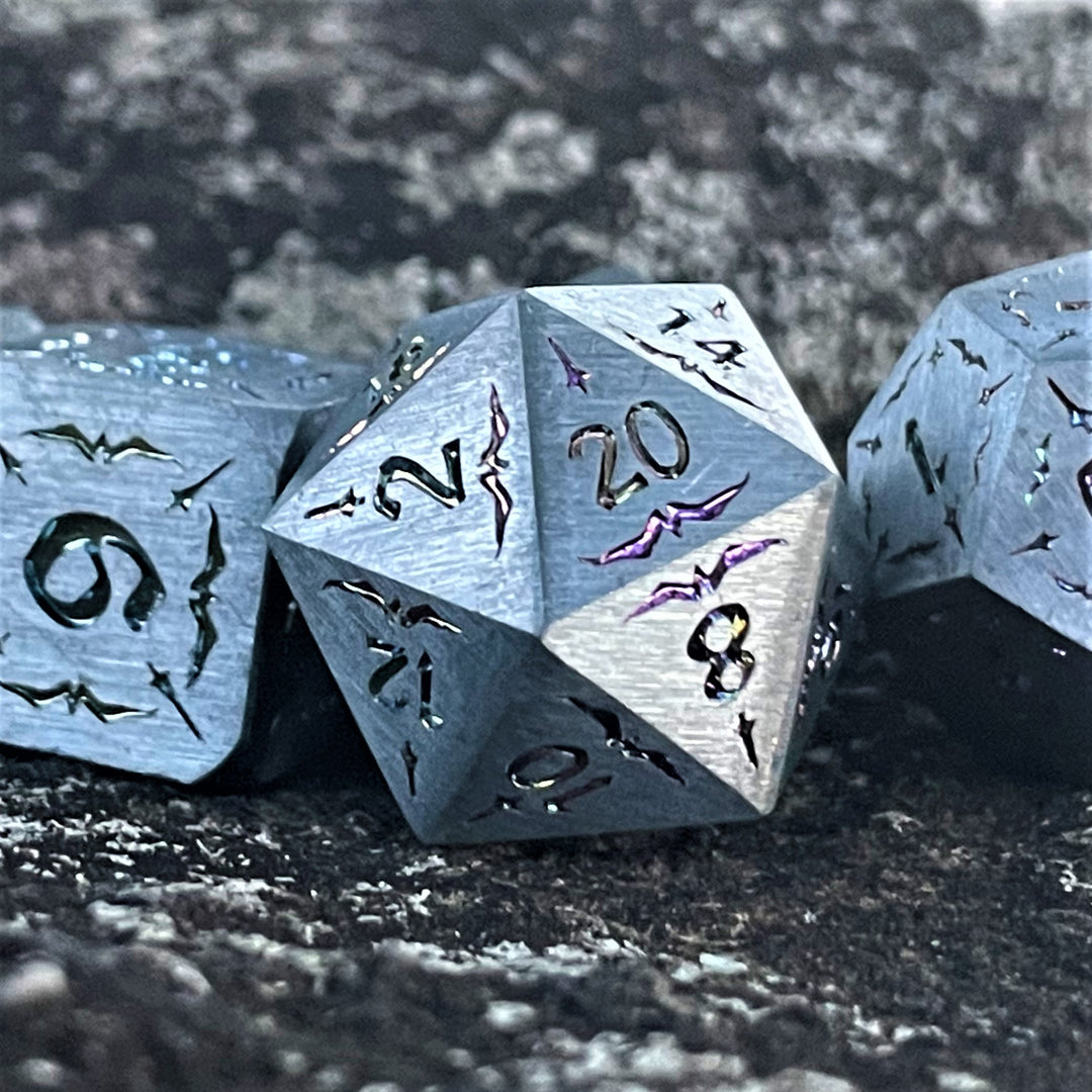 A set of solid silver metal dnd dice with iridescent numbering and sword details for tabletop gaming and board games. 