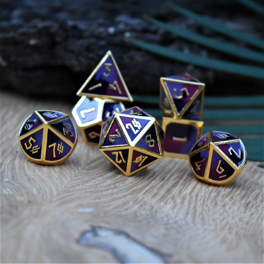 A set of metal dice that are different hues of purple with gold numbers and border for tabletop gaming and board games