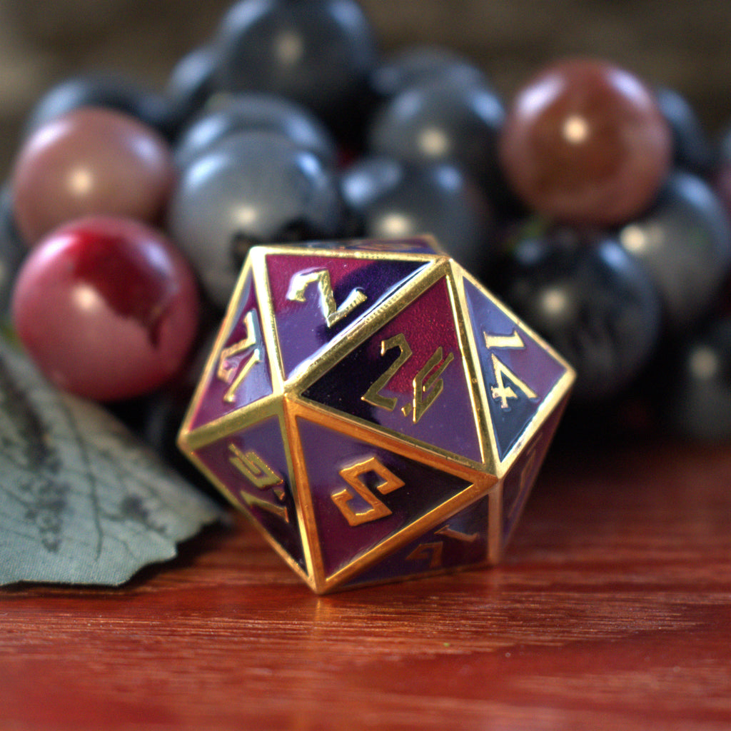 A set of metal dice that are different hues of purple with gold numbers and border for tabletop gaming and board games