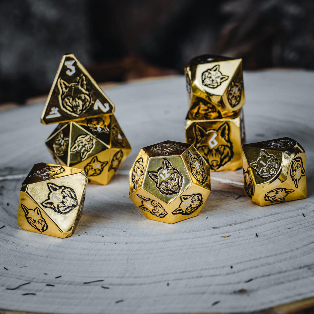 A set of gold metal dnd dice with black wolf designs and white numbers