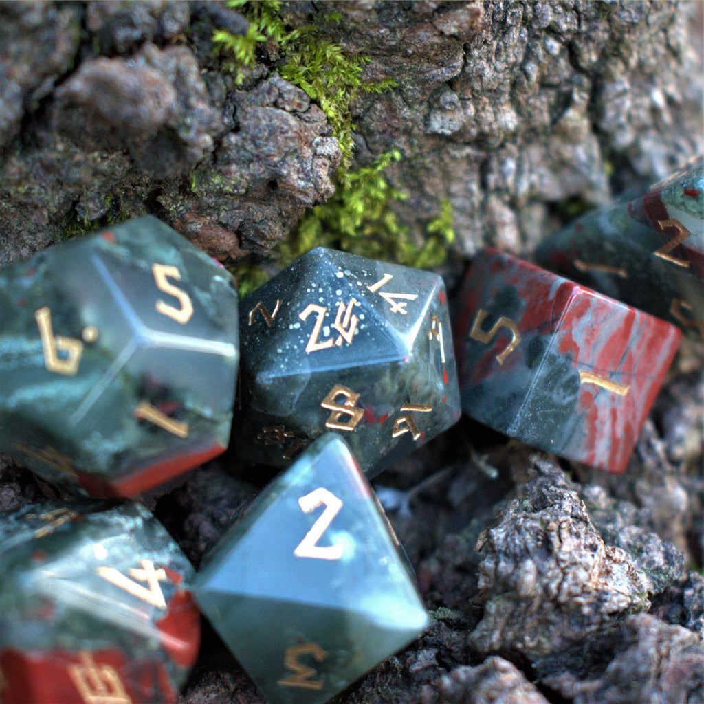 African bloodstone dice set that is grey with bursts of red and gold Nordic font numbers